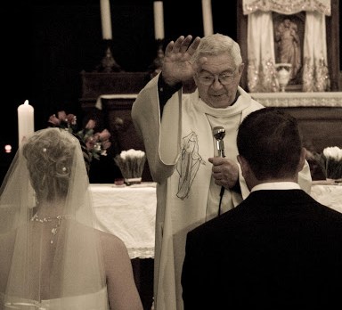 Priest blessing married couple