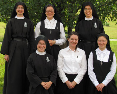 Passionist novitiate photo shows one nun in full vows, two in temporary vows, two postulants and and aspirant. God willing the postulants will become novices, wearing habits with white veils, and the aspirant will take on the postulant’s jumper and short veil. Used with Permission