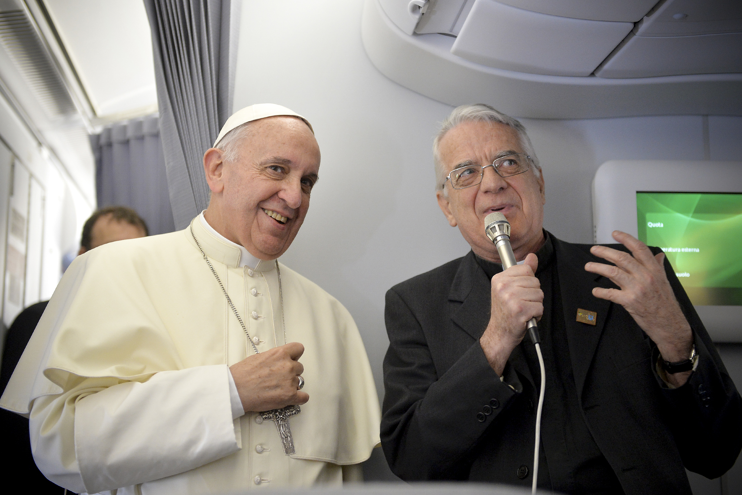Pope Francis (L) and father Federico Lombardi greet journalists of the papal flight upon arrival in Rio de Janeiro on July 22, 2013. Pope Francis landed in Brazil on Monday for his first overseas trip as pontiff to attend the international festival World Youth Day in Brazil, the world's biggest Catholic country.    AFP PHOTO/LUCA ZENNARO/POOL / AFP PHOTO / POOL / LUCA ZENNARO