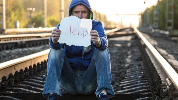 MAN WITH HELP SIGN