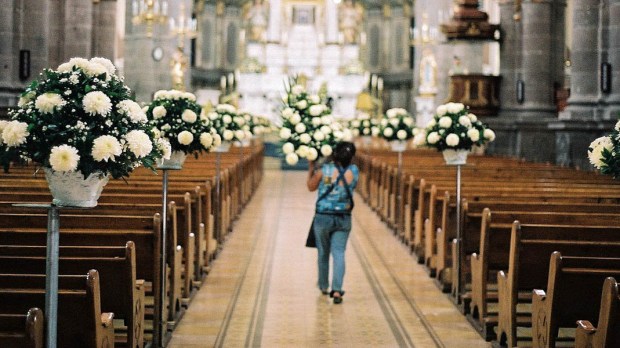 WOMAN DECORATING CHURCH WITH FLOWERS