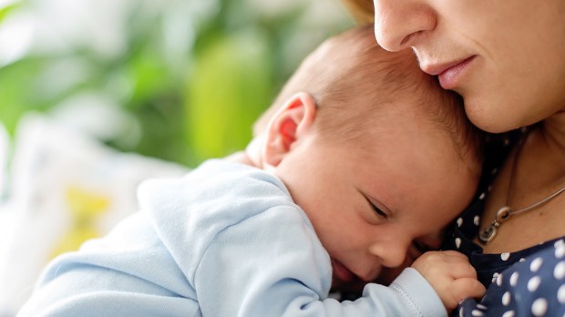 NEWBORN SNUGGLING WITH MOTHER