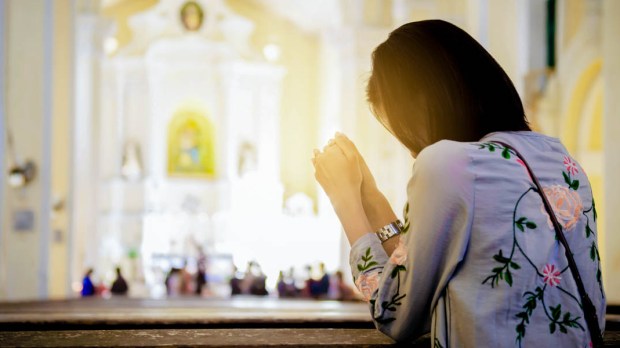 WOMAN KNEELING AT CHURCH