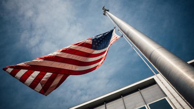 US flag on pole outside of building