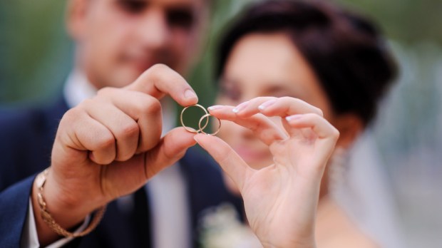 bride and groom holding hands in a ring