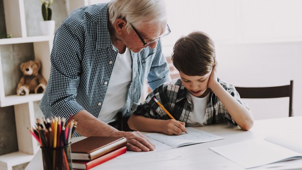 Grandson-Doing-School-Homework-with-Old-Man-Home.-shutterstock