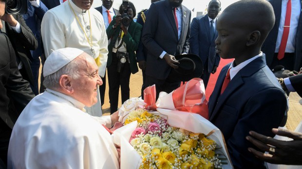 Pope Francis receiving a bouquet of flowers from a child as the Pope arrives at the Juba International Airport in Juba South Sudan