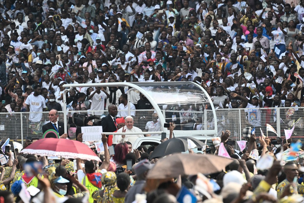 Pope Francis waves as he arrives by popemobile for a meeting with young people and catechists at Martyrs' Stadium in Kinshasa