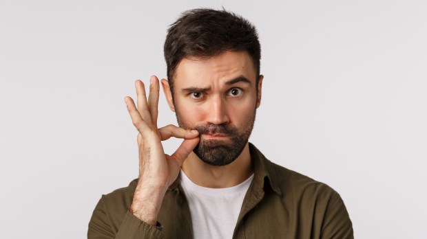 Serious and funny bearded adult man keep mouth shut