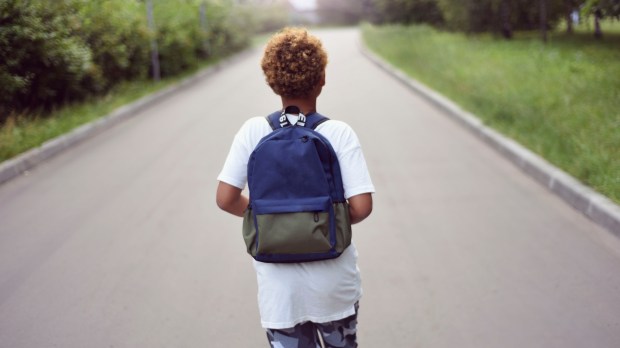 American boy walking to school with backpack
