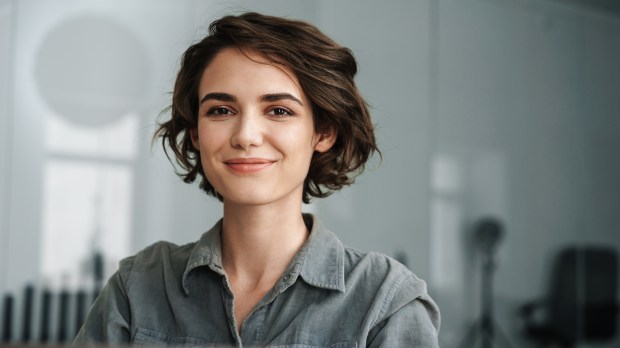 young woman smiling sitting at laptop