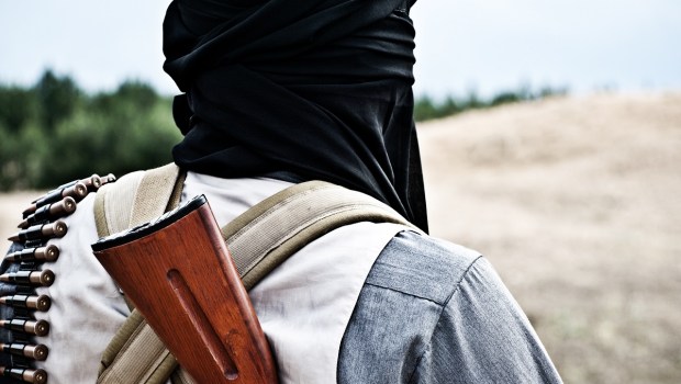 Masked terrorist with gun and bullets