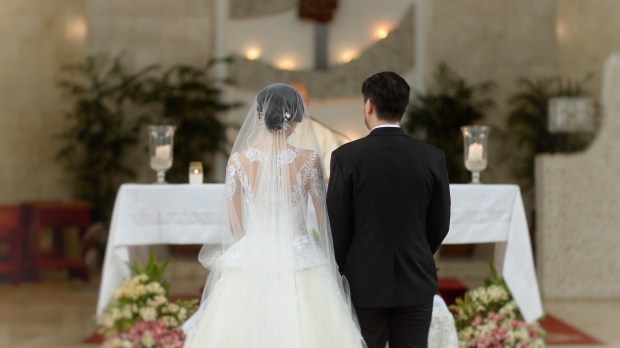 Bride and groom before altar with backs to camera