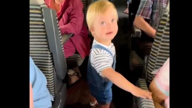 Screen capture of little boy greeting passengers on a train