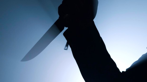 silhouette of criminal holding knife in close up