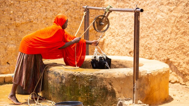 woman drawing water well
