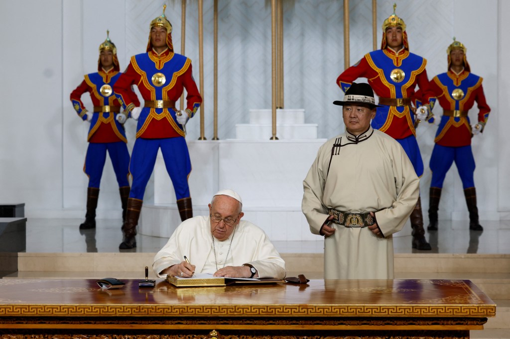 Pope Francis signs the honour book alongside Mongolia's President Ukhnaagiin Khurelsukh during a courtesy visit at the State Palace in Ulaanbaatar on September 2 2023