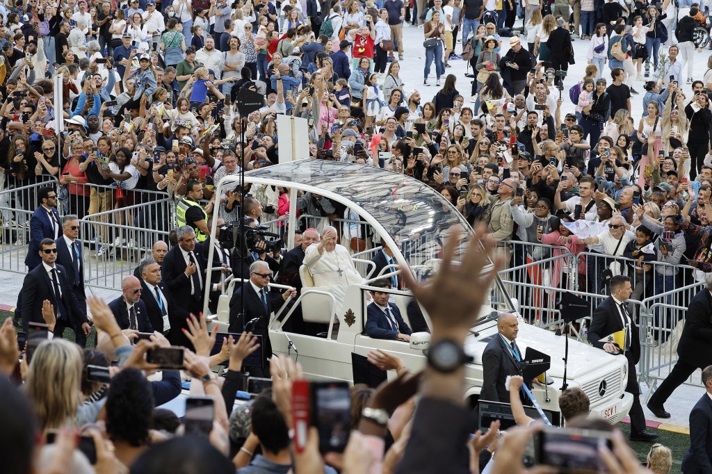 Pope Francis waves as he arrives in his popemobile to celebrate mass at the Velodrome stadium