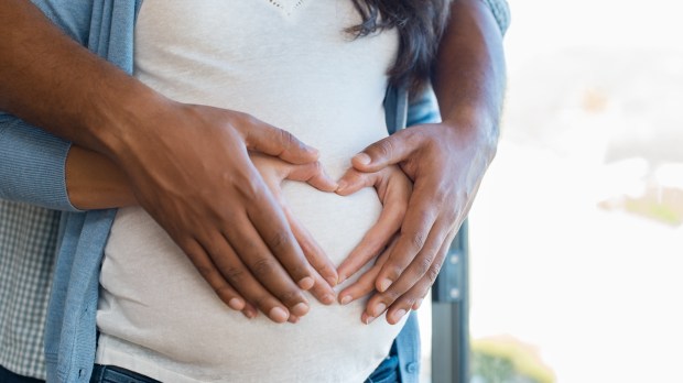 Father of child embraces his pregnant wife