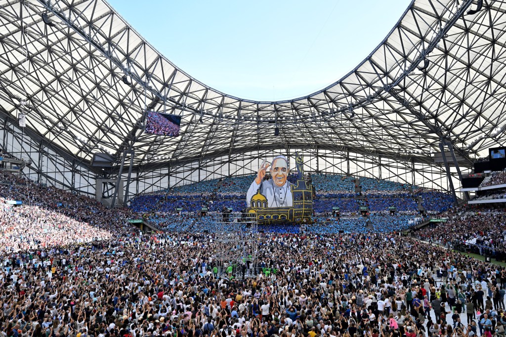 Supporters of the Olympique de Marseille football club hold up a huge banner of Pope Francis as he arrives to celebrate mass at the Velodrome stadium in the southern port city of Marseille