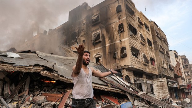 Man shouts in front of bombed Gaza building