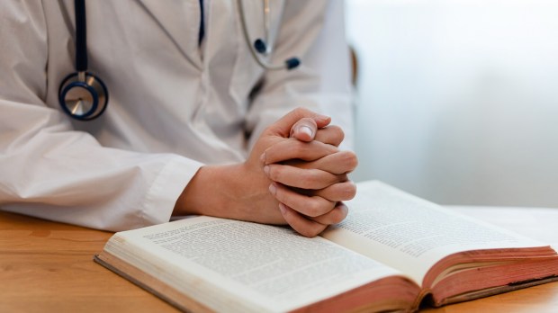 doctor praying with bible