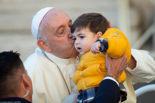 Pope Francis Kisses a child at the end of his weekly general audience in St. Peter's square
