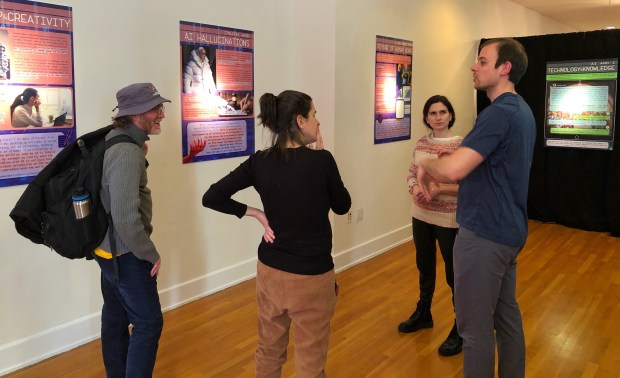 A guide leads visitors through the "AI and I" exhibit at the 2024 New York Encounter.