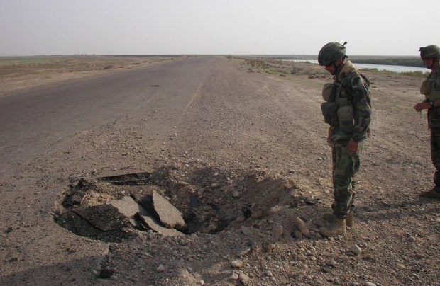 The crater from the IED explosion described in the article.