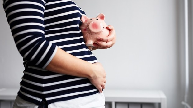 Pregnant woman with piggy bank