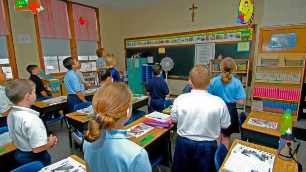 Kids in school look at crucifix