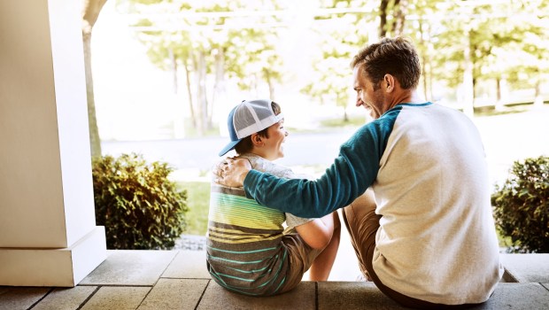 Father and son talking on porch